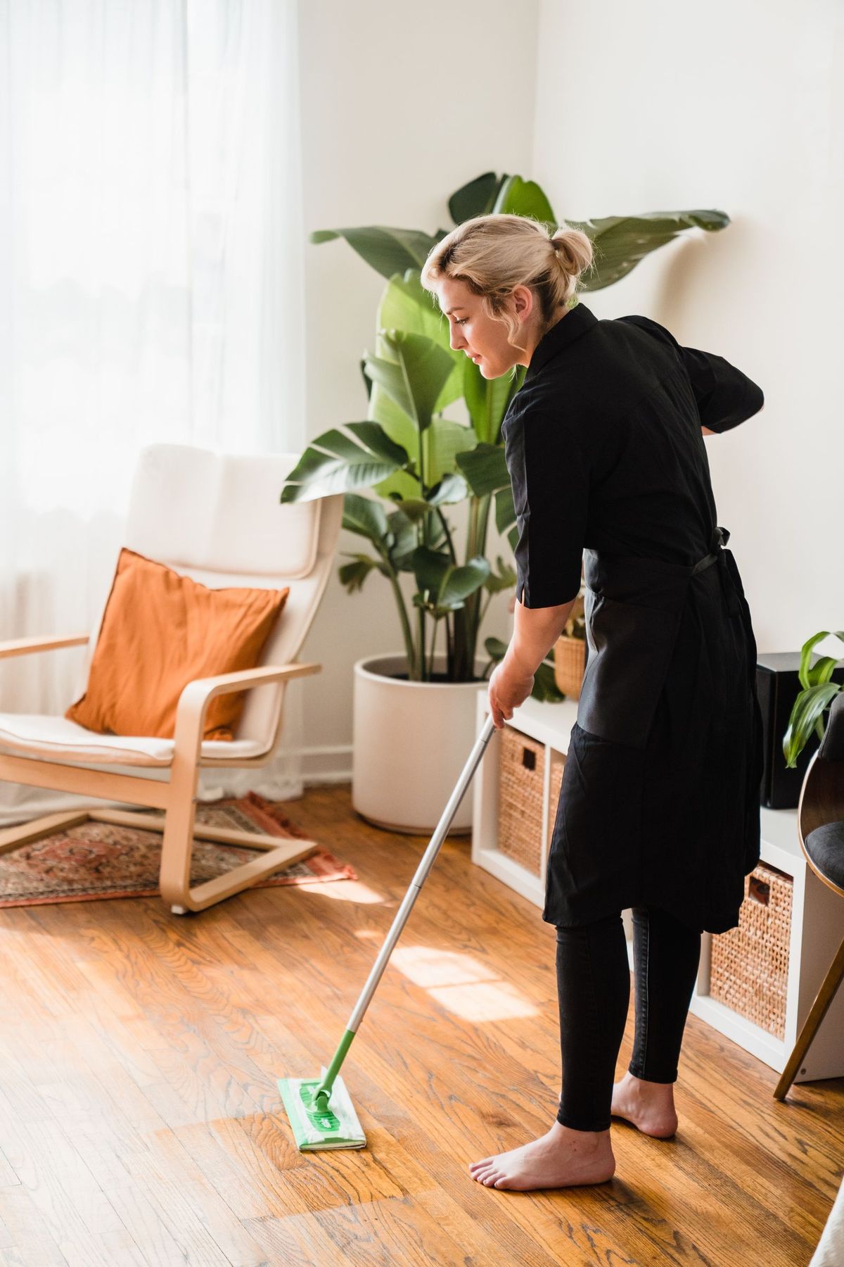 CleanKaki cleaner mopping a sunlit living room floor