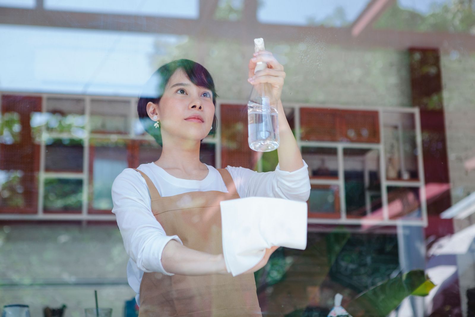CleanKaki cleaner wiping a glass window at a commercial premises